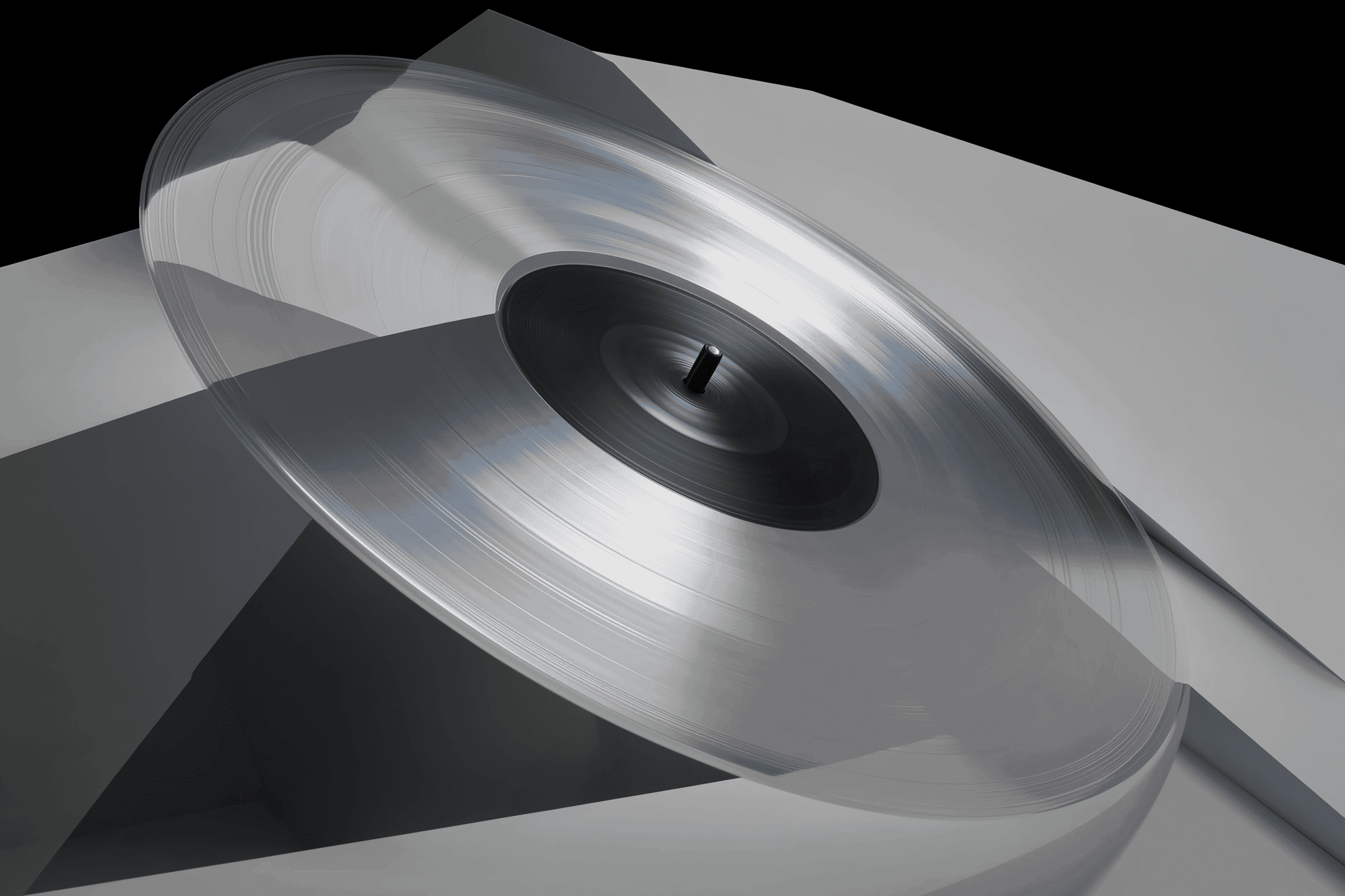 Minimalist turntable setup with silver geometric forms on a light gray surface