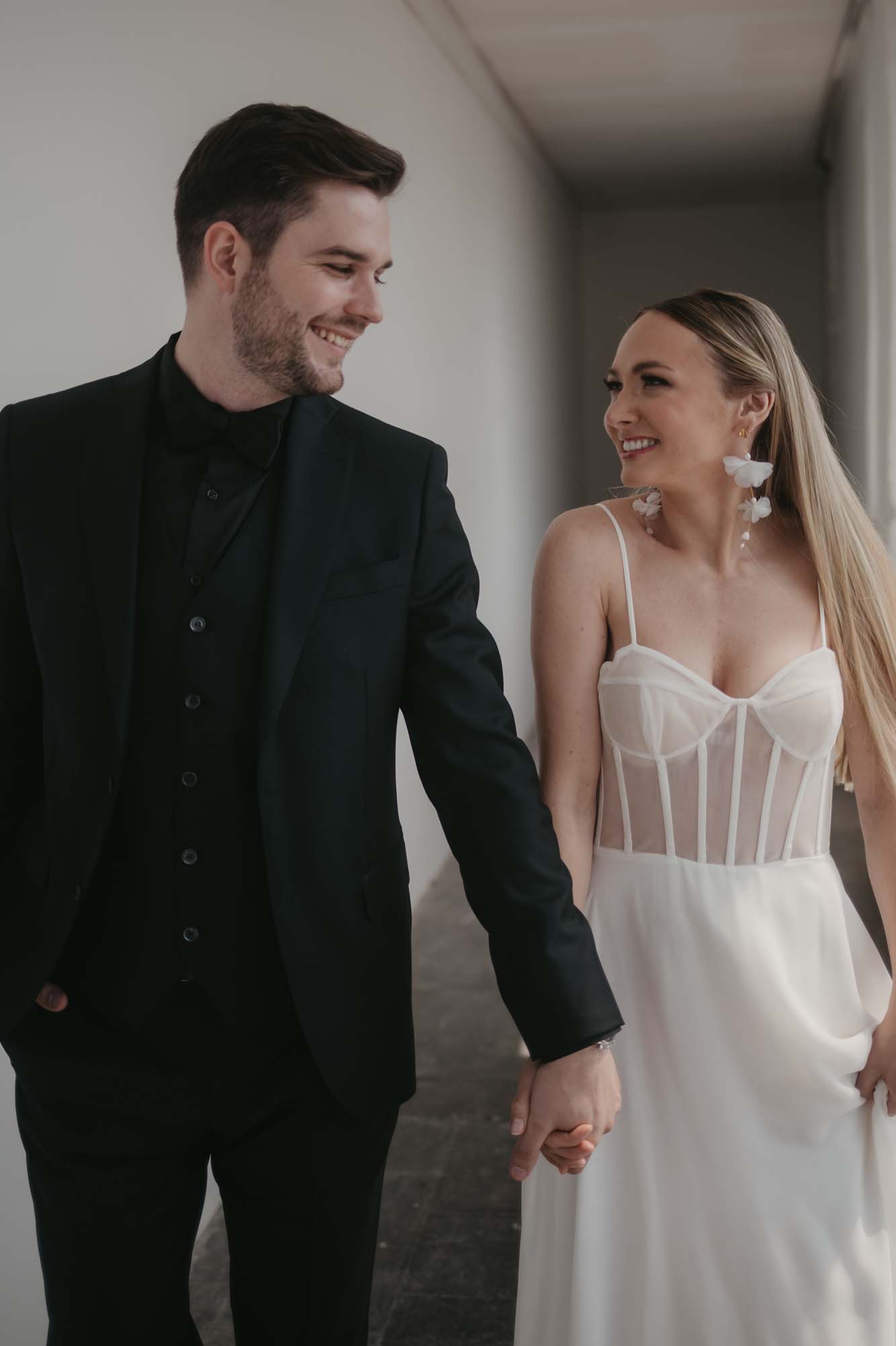 Brautpaar schaut sich lachend an und hält sich an den Händen.