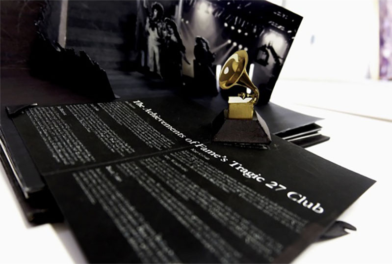 A black cover o a book with white text and an image of some golden music instrument alongside.