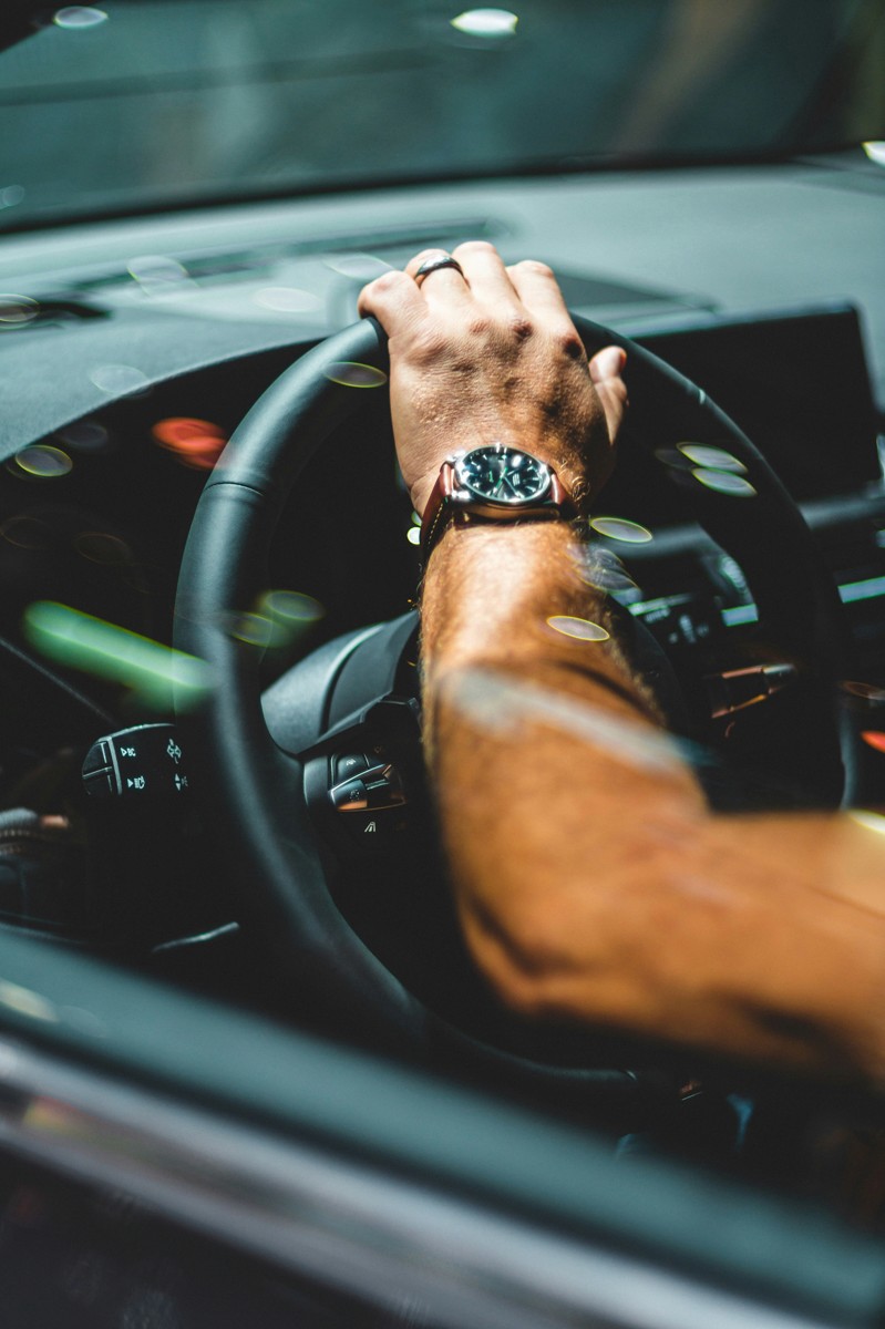 Mão ao volante com luzes nocturnas em bokeh — Táxi Afonso · 06 Caminha