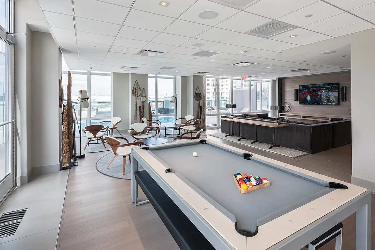 An expansive room showcasing a pool table alongside a wall-mounted television.