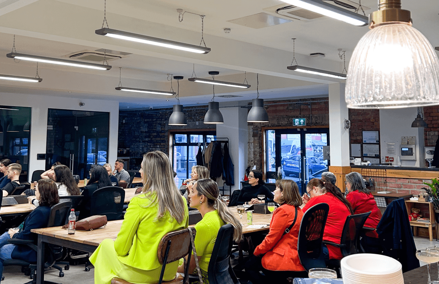People sitting in a library with many windows.