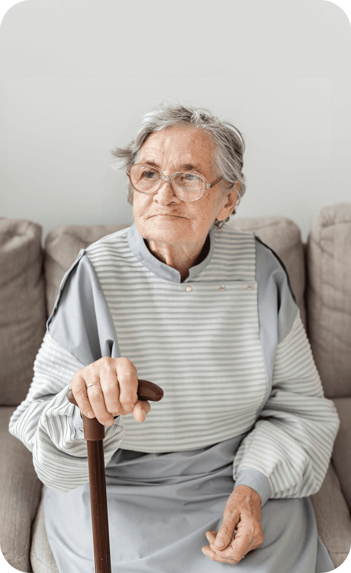 idosa sentada no sofá com a sua bengala