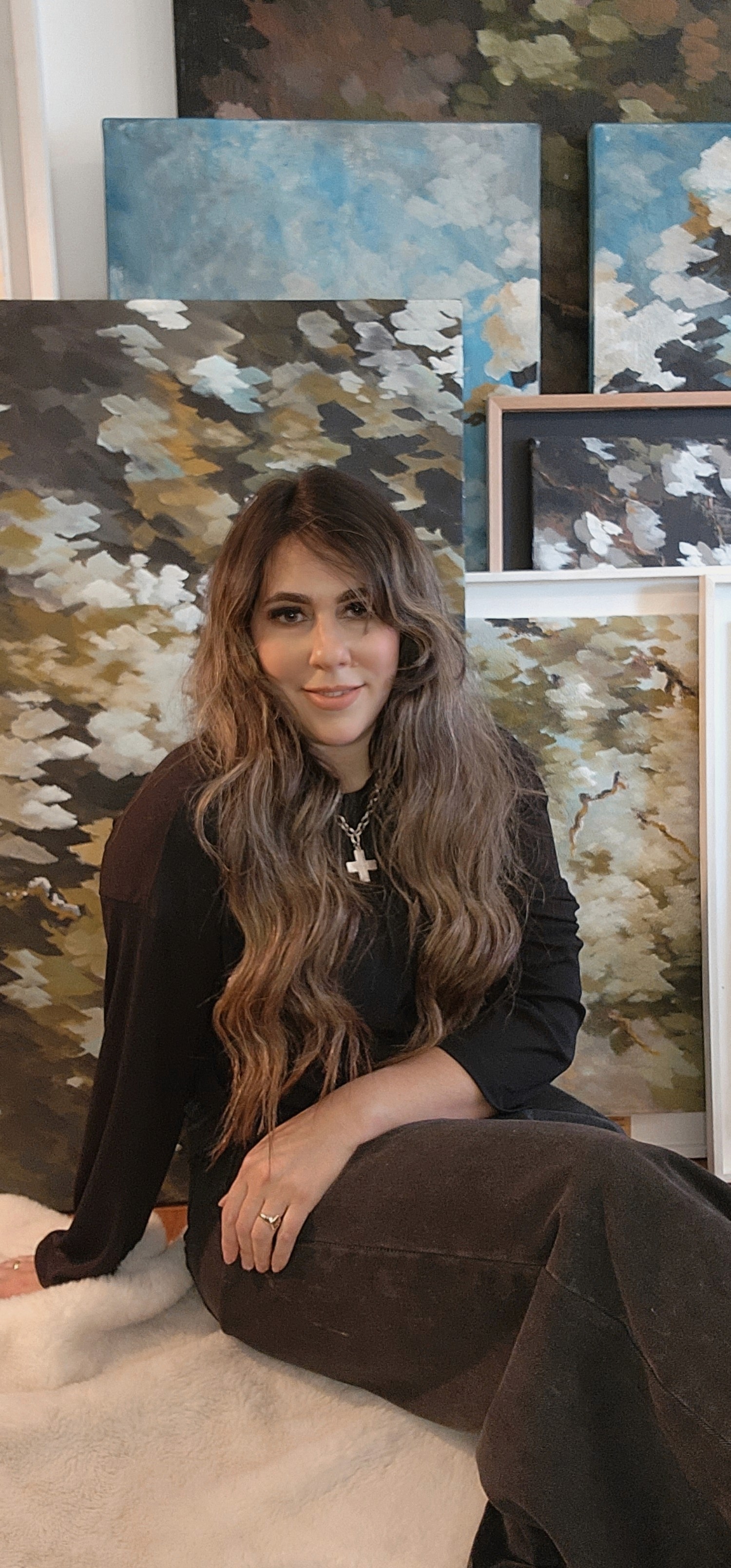 Belén posing next to her paintings
