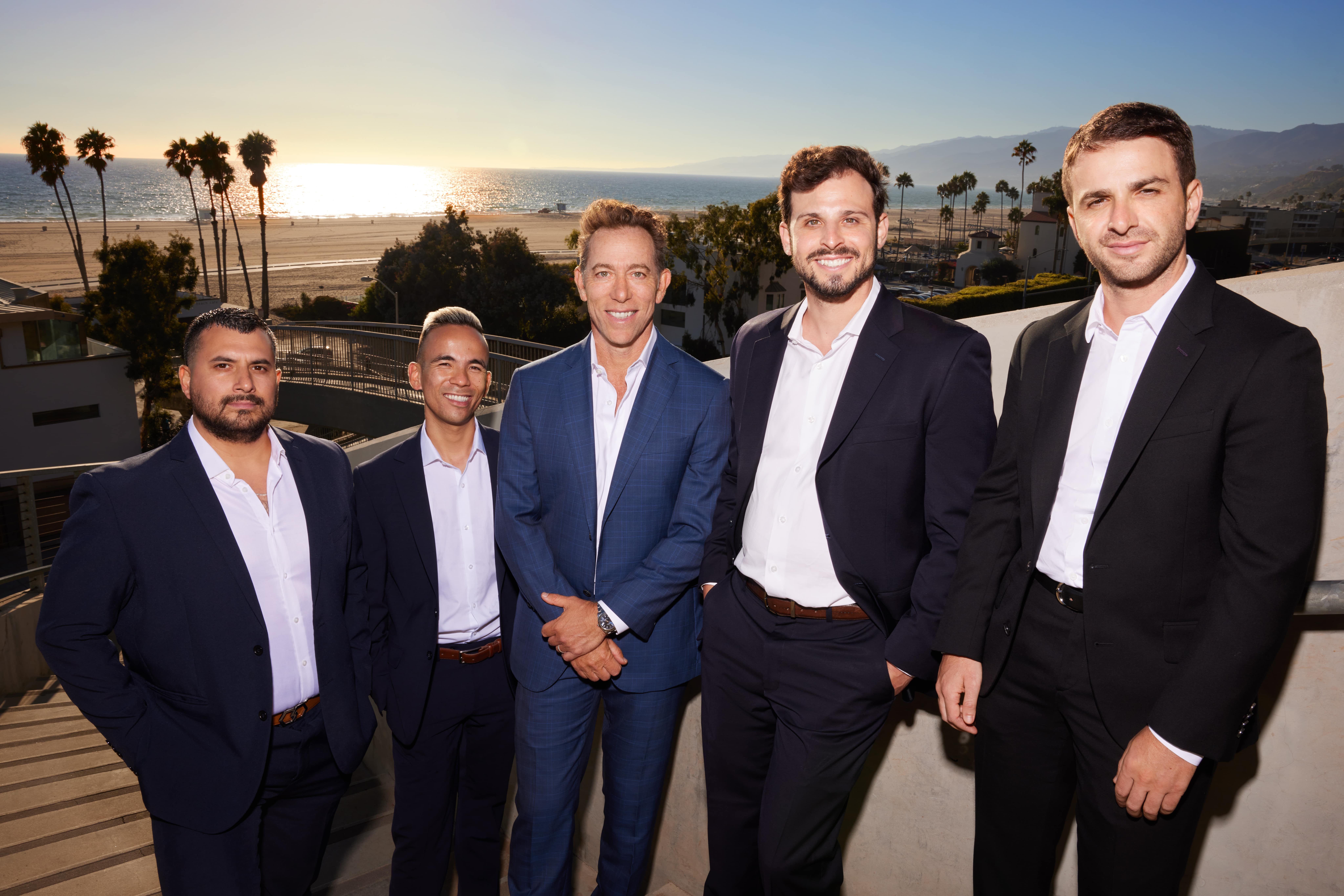 Los Angeles multifamily real estate brokers team photo at sunset on luxury apartment building rooftop