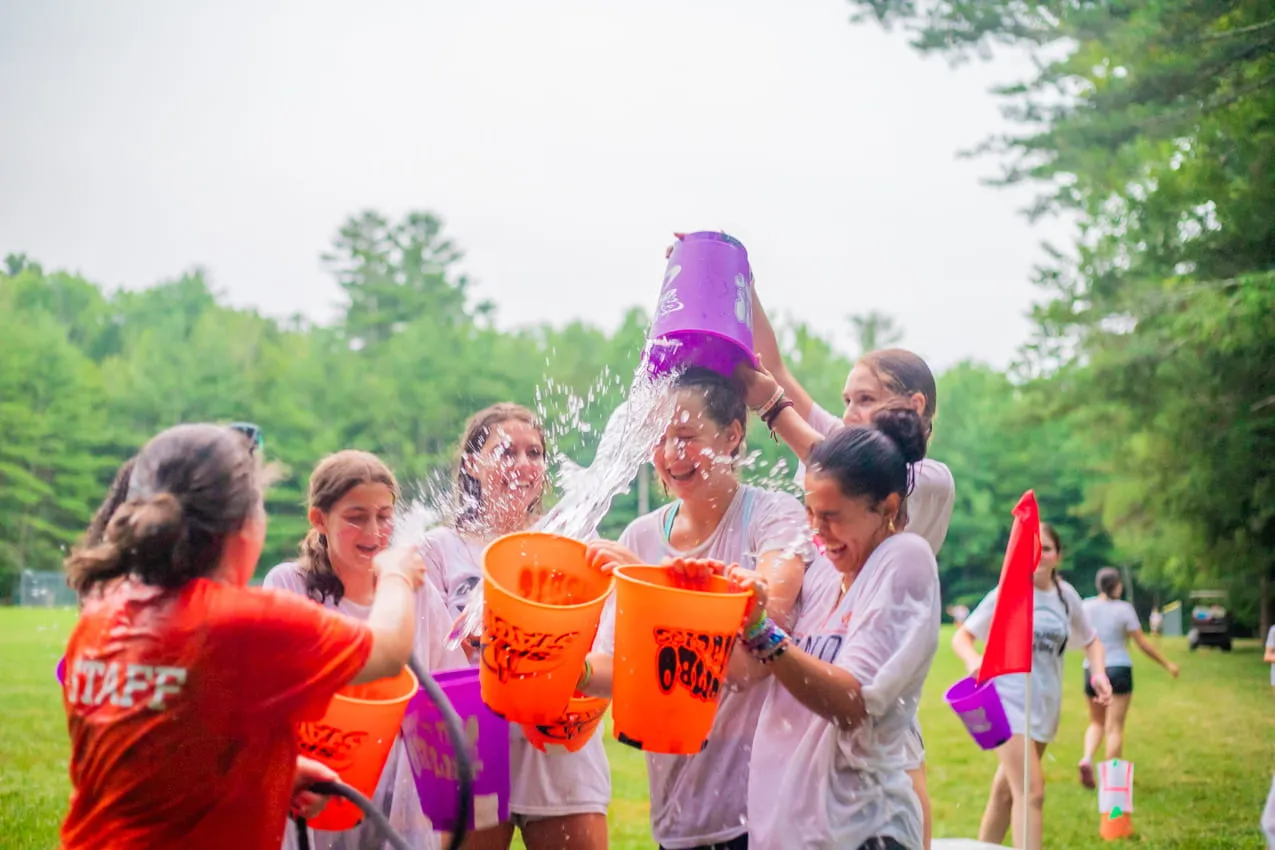 Campers dumping a bucket of water over each other during a camp game