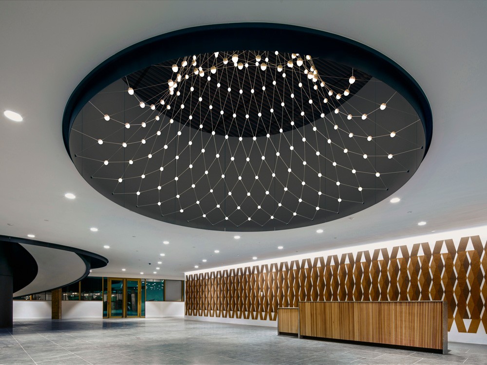 Botswana Innovation Hub lobby featuring a 5-meter-wide circular lighting installation with 242 custom LED nodes suspended in a steel cable net
