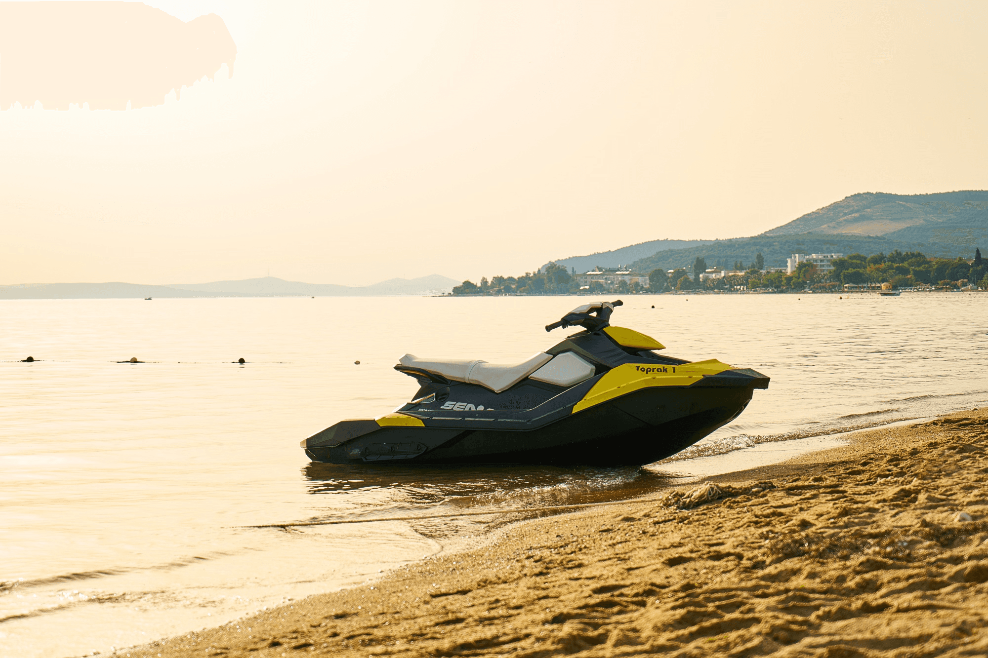 A Sea Doo jet ski parked on the beach coastline.