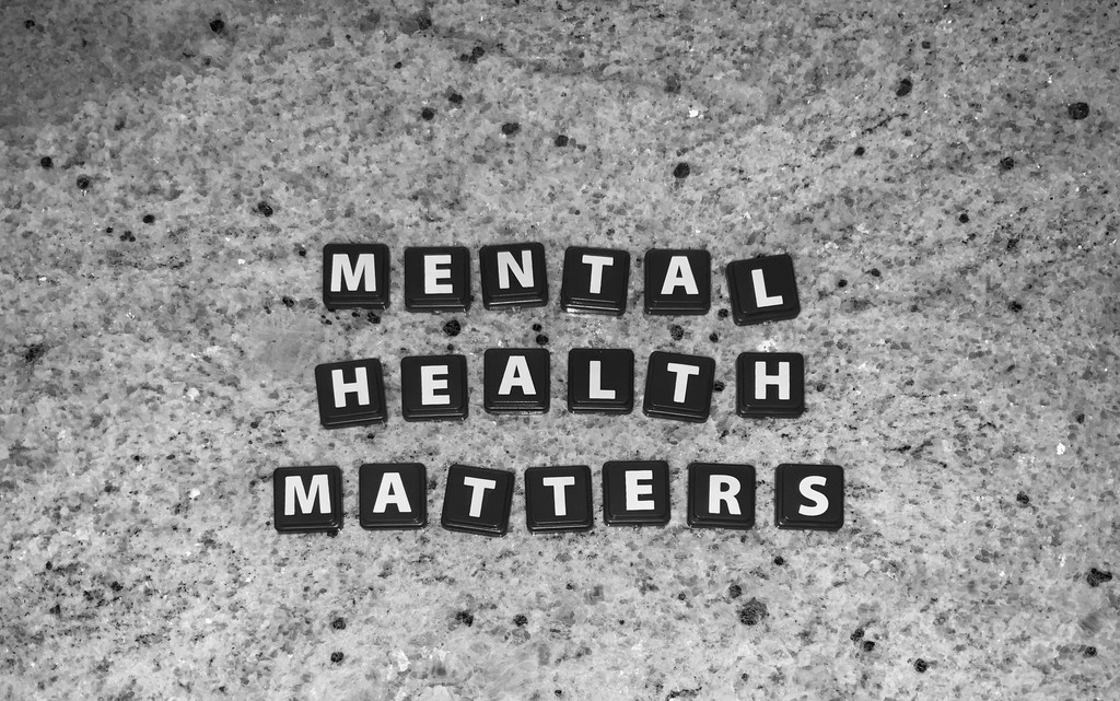 The words "Mental Health Matters" are spelled out using black letter tiles on a textured, granite-like surface.