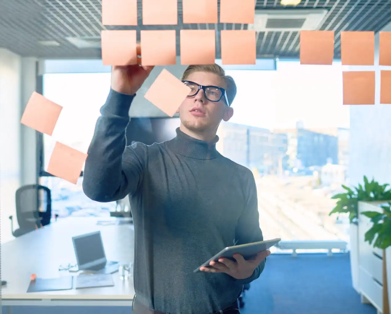 Manager schreibt Ideen und Strategien auf Glaswand im Büro