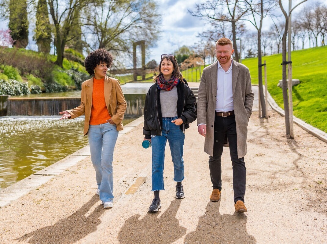 group of friends taking a walk in a park on their lunch break to add to their goal of how many miles to lose weight