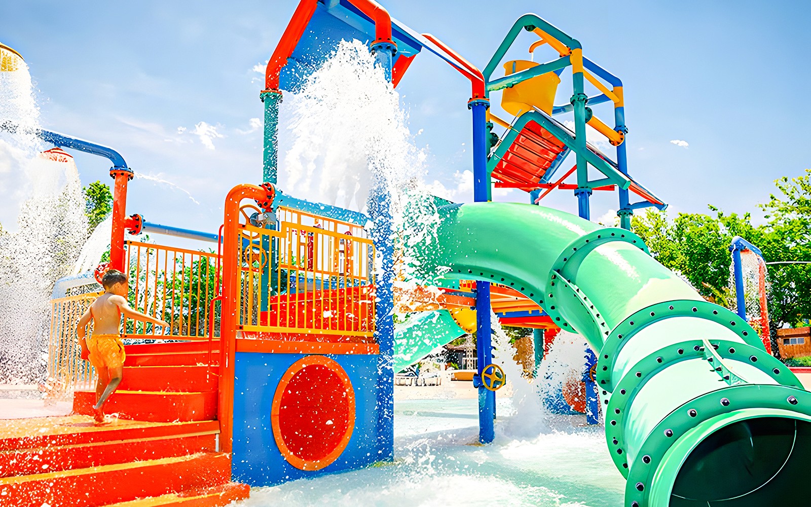 Child playing at Aquopolis water park's colorful zona infantil with slides and fountains.
