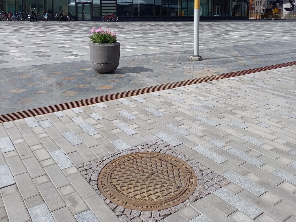 Close-up de pavimento com tampa de bueiro.