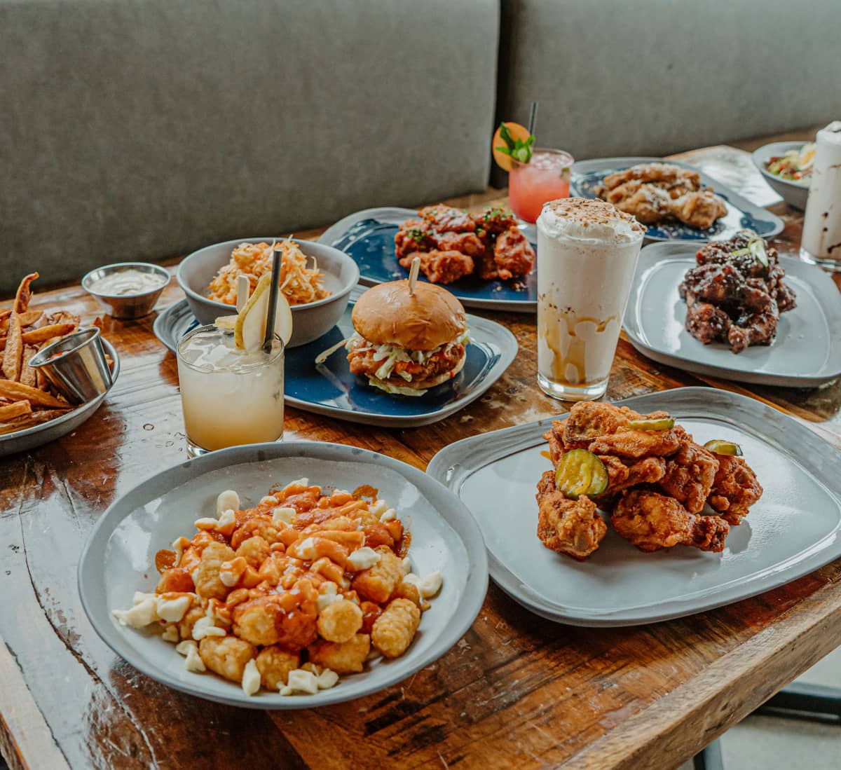 Plusieurs plats d'ailes de poulet et burgers sur une table de restaurant