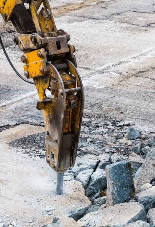 A construction tractor is breaking ground.