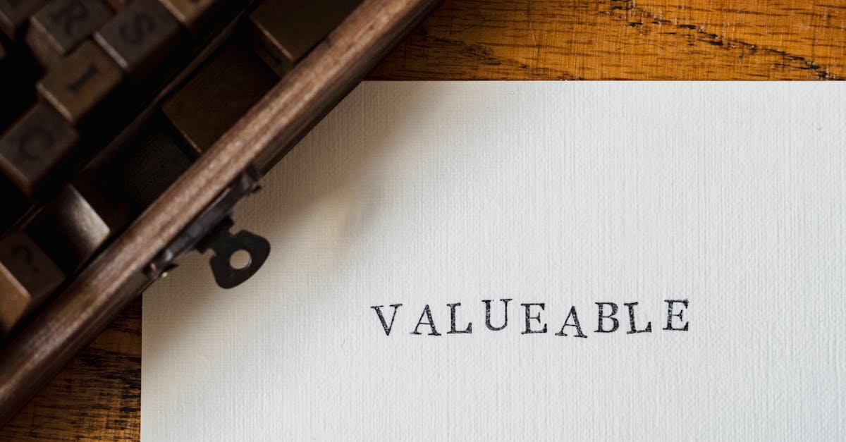 A classic typewriter typing 'VALUEABLE' on a white sheet on a wooden table.