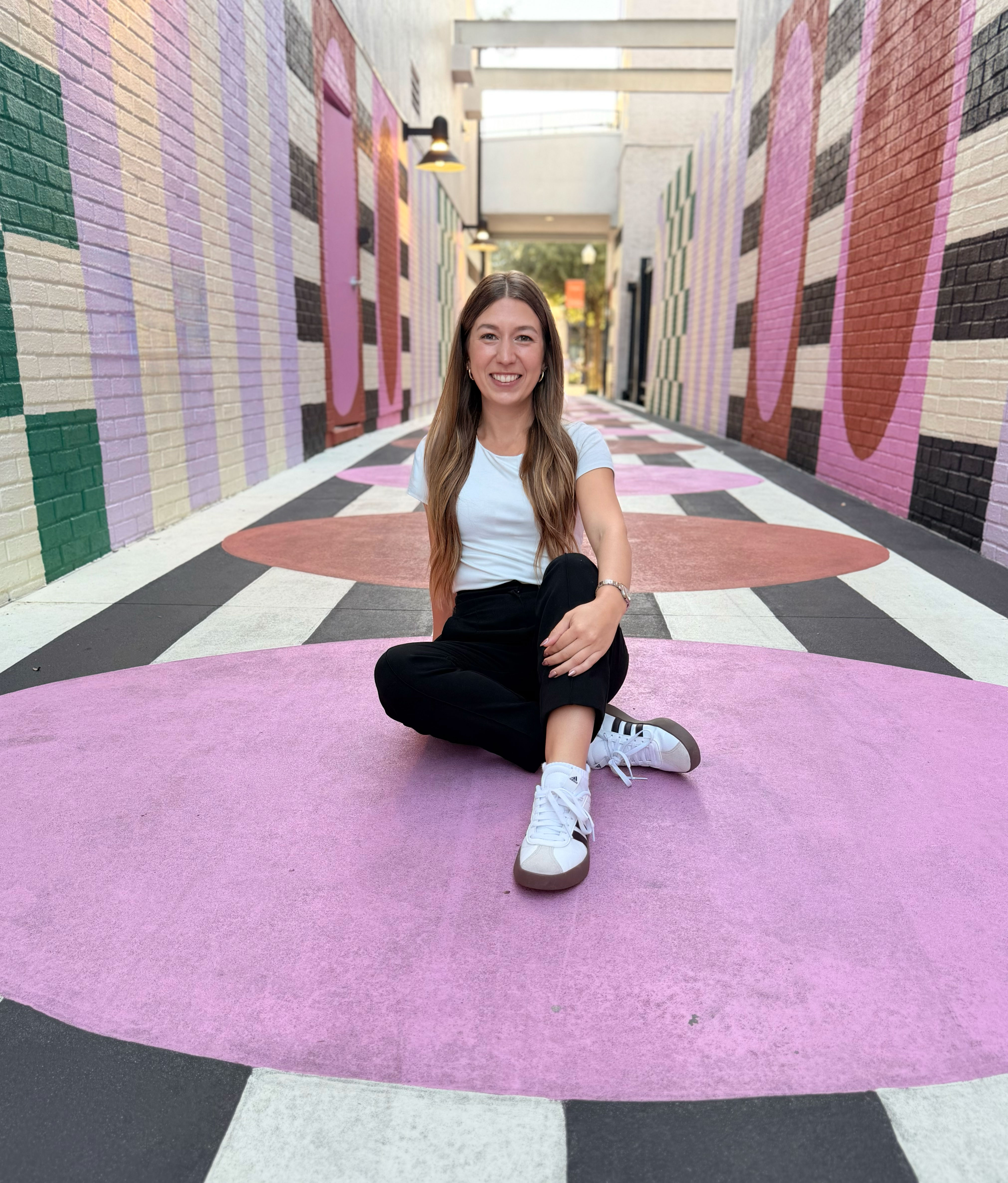 Julie Morris sitting in a colorful outdoor walkway in Hyde Park, Tampa Bay