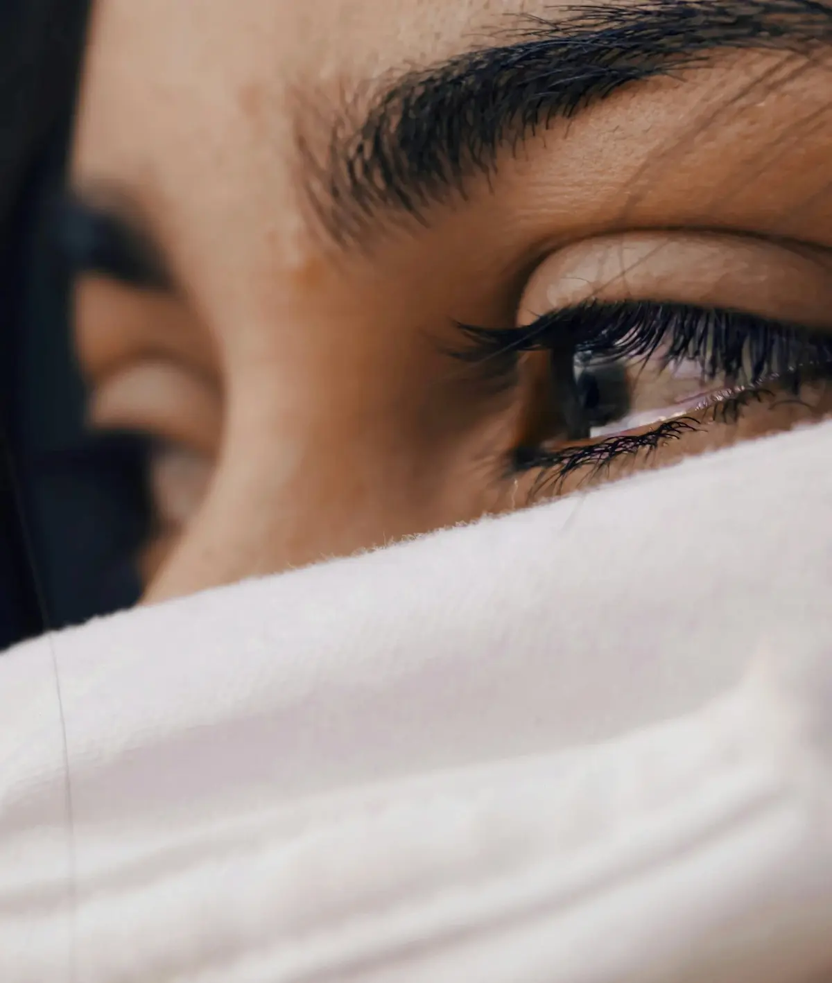 Close-up photo of a person’s eyes expressing emotional exhaustion—representing empathy fatigue, overwhelm, and the mental health impact of constant stress in today’s world.