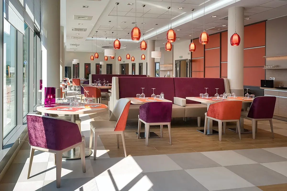 Restaurant lumineux au mobilier coloré — photographie hôtellerie Lille Nord 2025 | Anteale Yann Manac’h