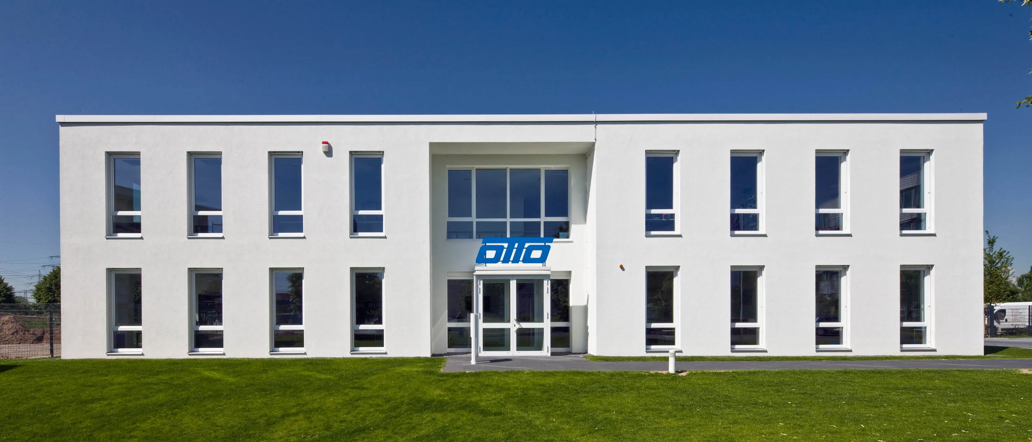 Modernes weißes Bürogebäude mit vielen großen Fenstern und dem blauen Schriftzug "diio" über dem Haupteingang.