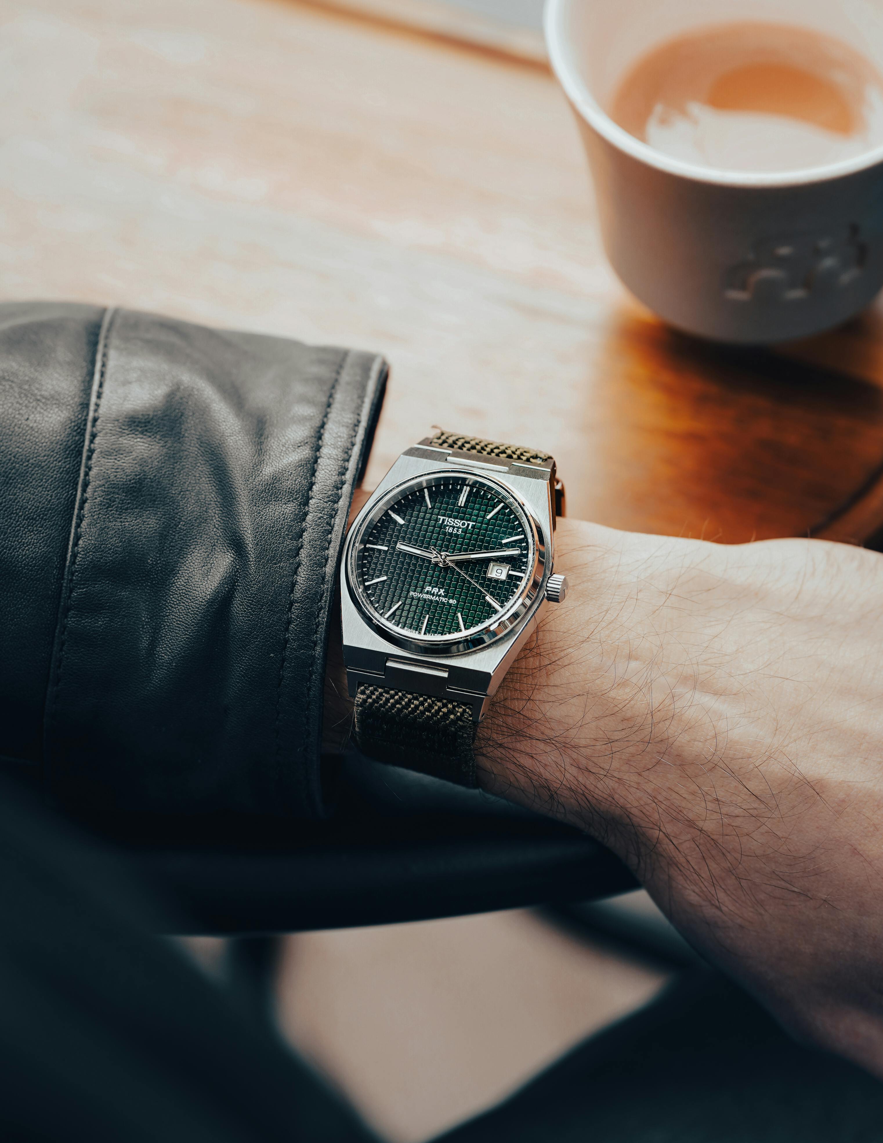 Tissot PRX with a green waffle dial and fabric strap on a man's wrist