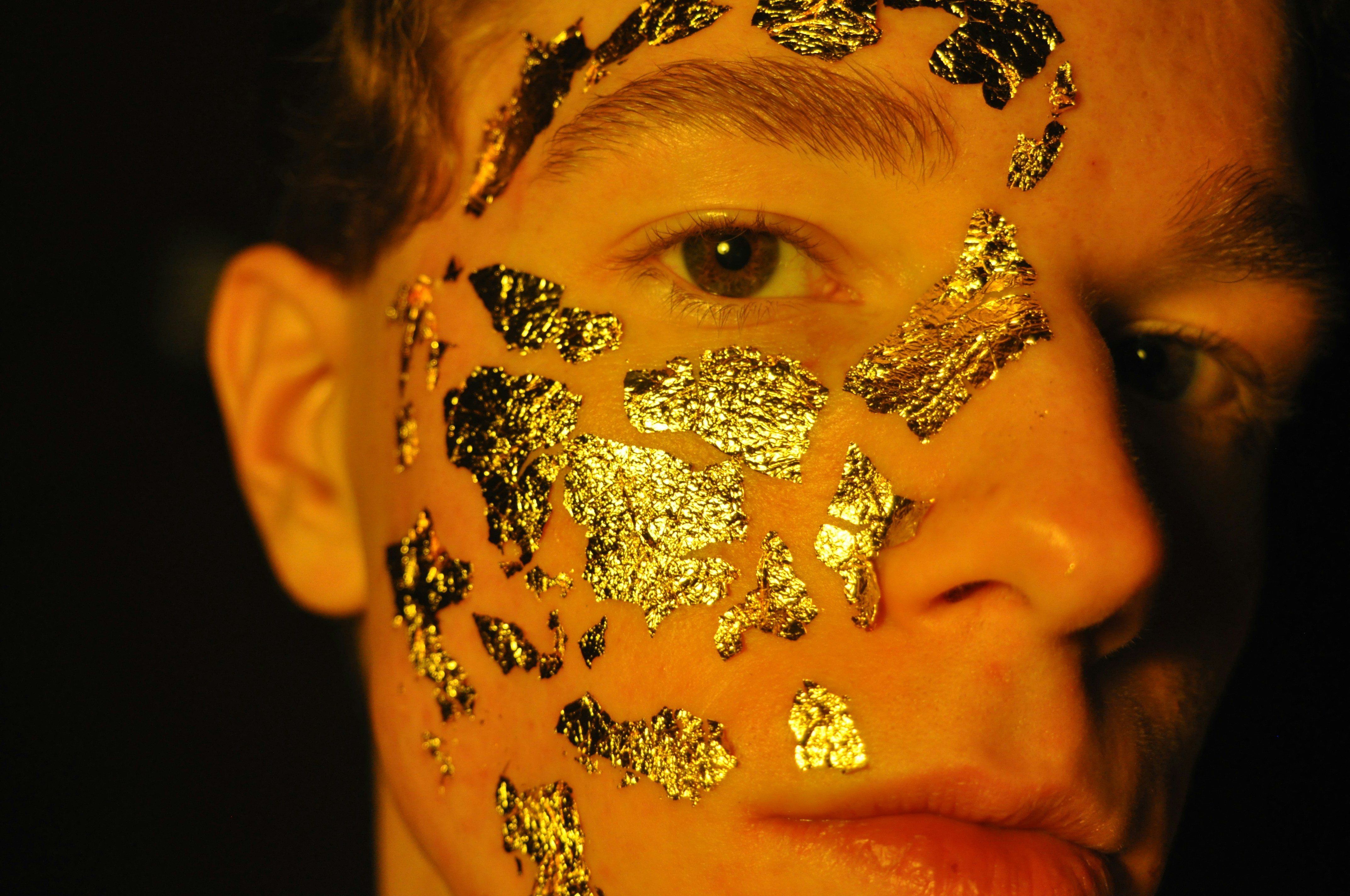 person with gold and silver floral face paint