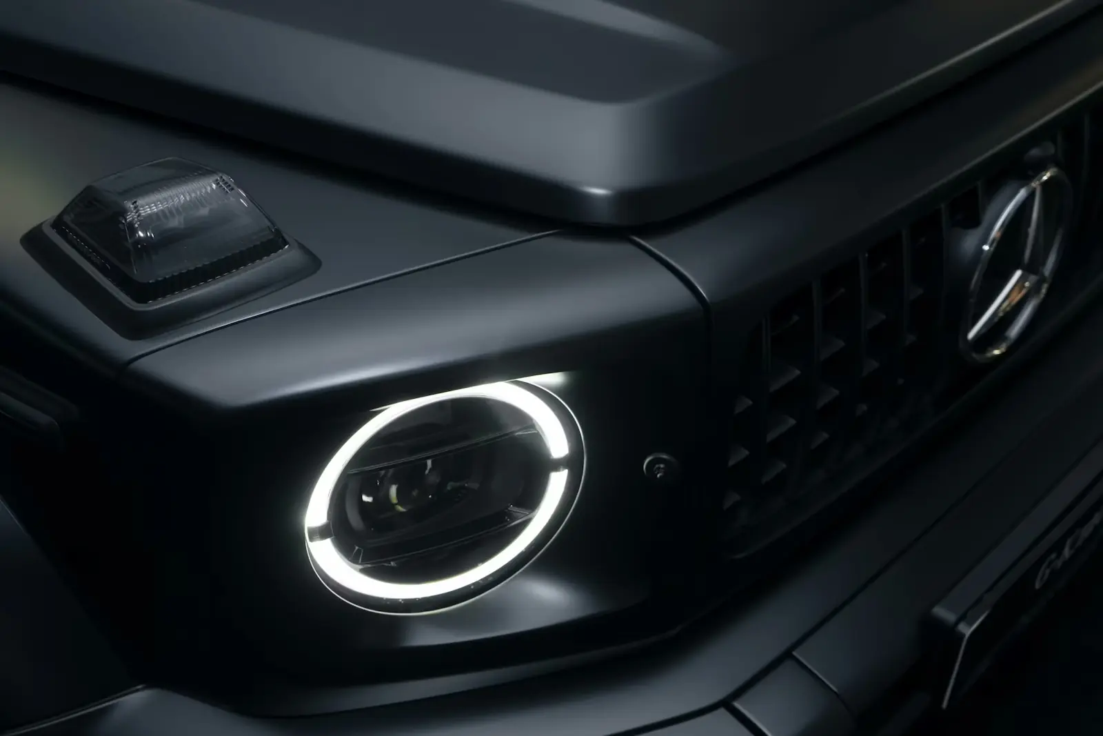 Face avant d’un Mercedes Classe G noir mat dans un univers premium