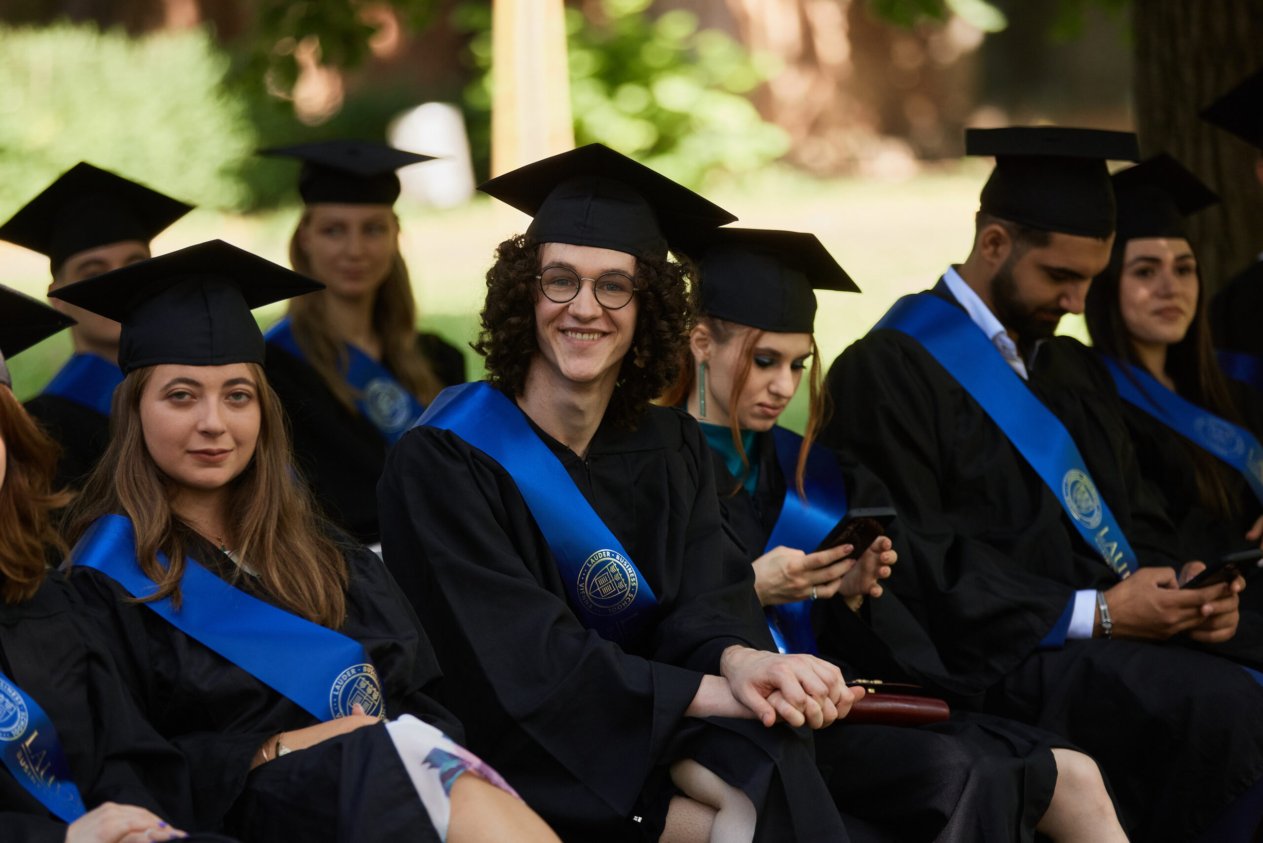 Group of diverse students collaborating and looking at a tablet together