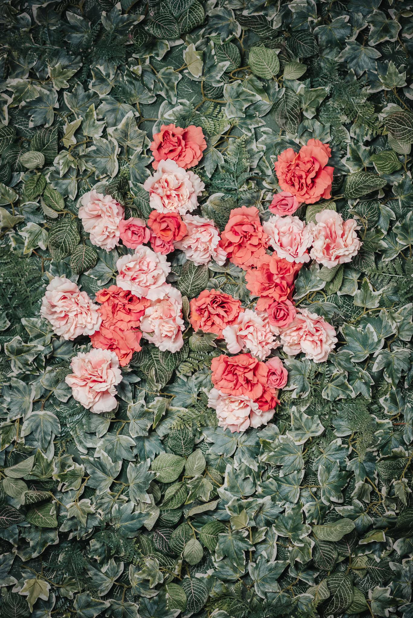 Modern home office setup with a monitor, ergonomic chair, keyboard, and indoor plants near a window with blinds.