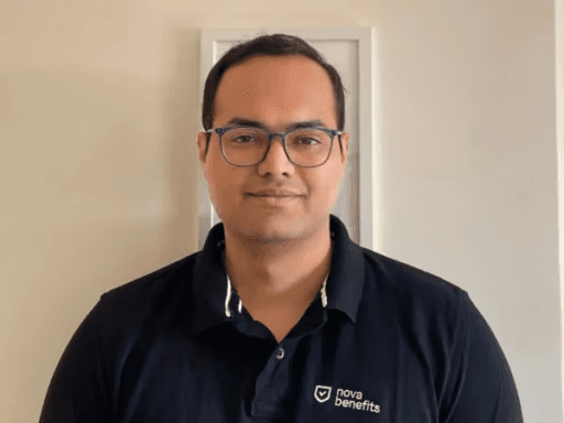 Man in a teal headband and shirt wearing orange-tinted glasses, looking forward with a serious expression.