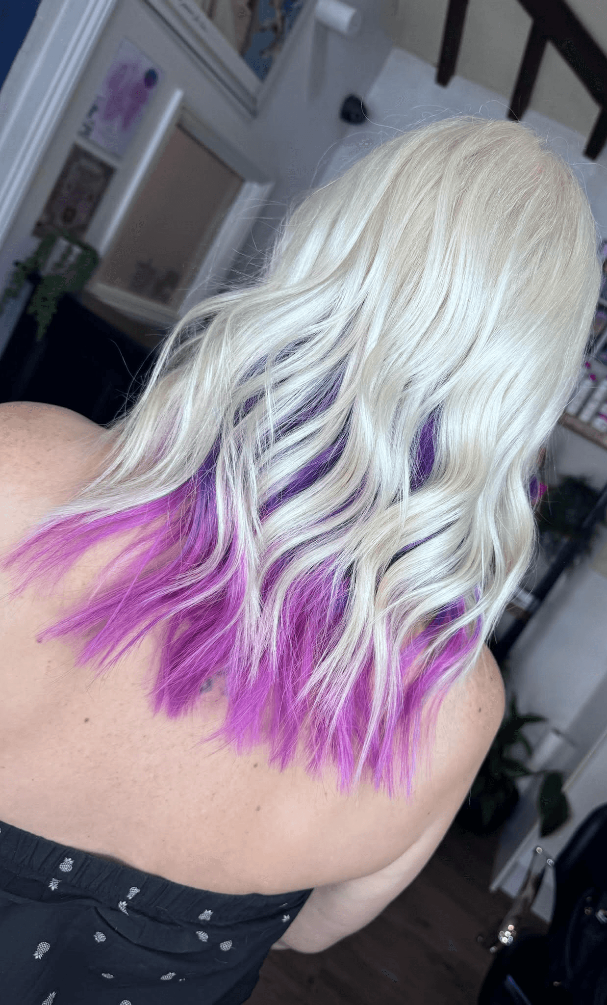 Woman with long wavy blonde hair with purpler highlights at Inspire Studio Salon