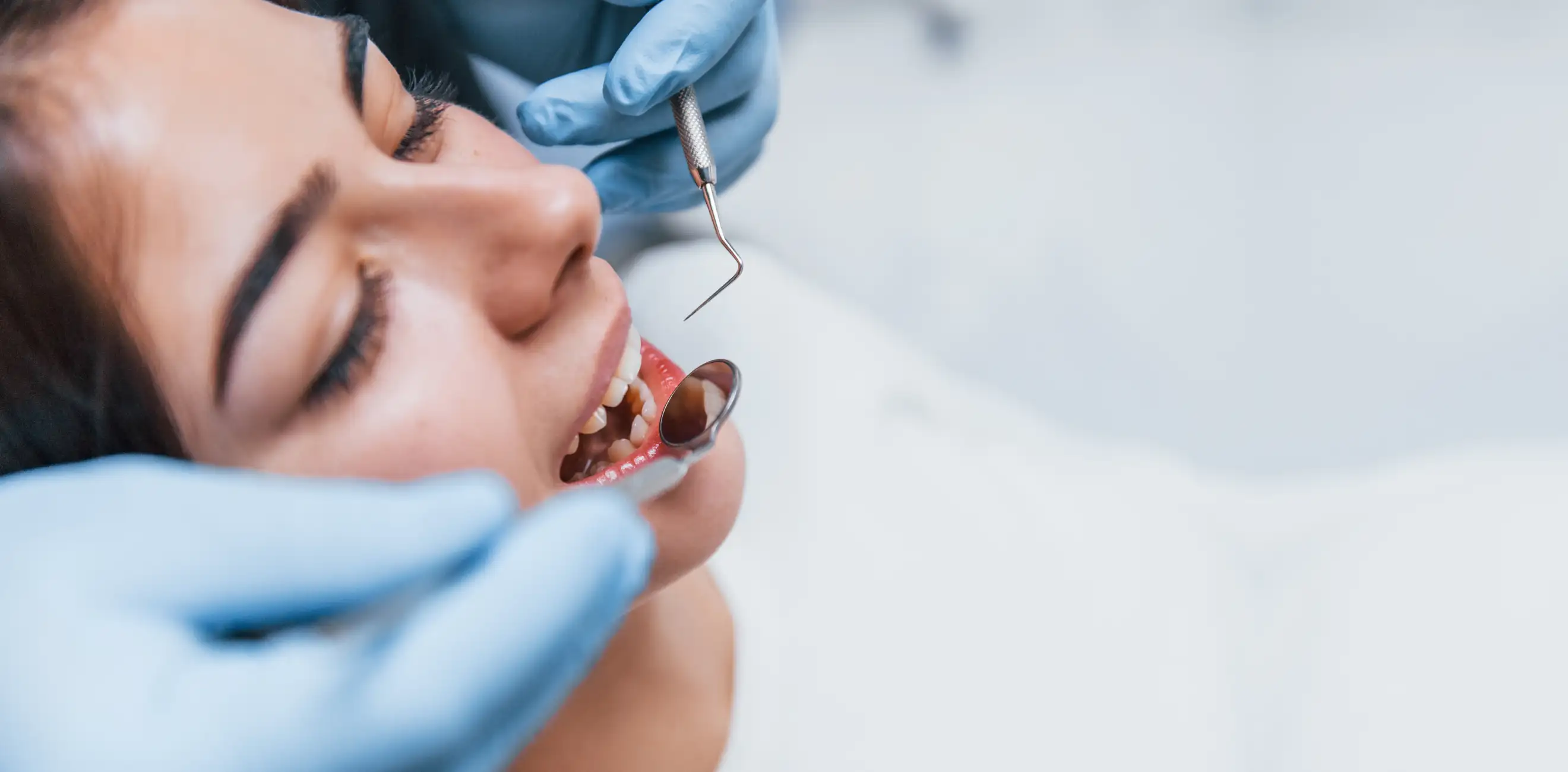 Kobieta na fotelu stomatologa podczas zabiegu higienizacji.