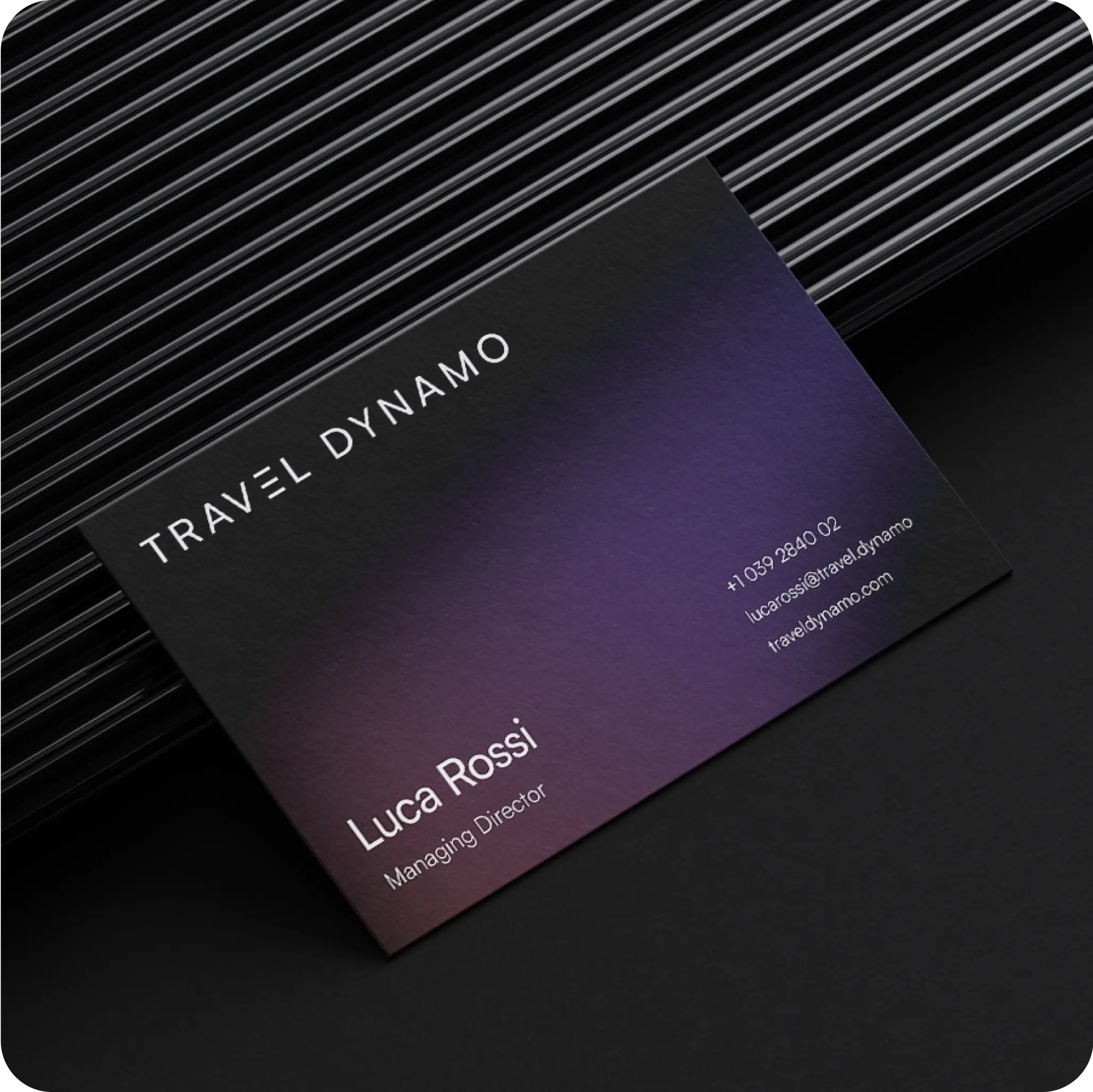 Elegant business card for 'Travel Dynamo' presented on a textured, black background. The card features a gradient from purple to black with white text. It displays the company name 'Travel Dynamo' at the top, followed by the name 'Luca Rossi' and the title 'Managing Director'. Below, contact details include a phone number and an email address, all arranged neatly to maximize readability and professional appeal.