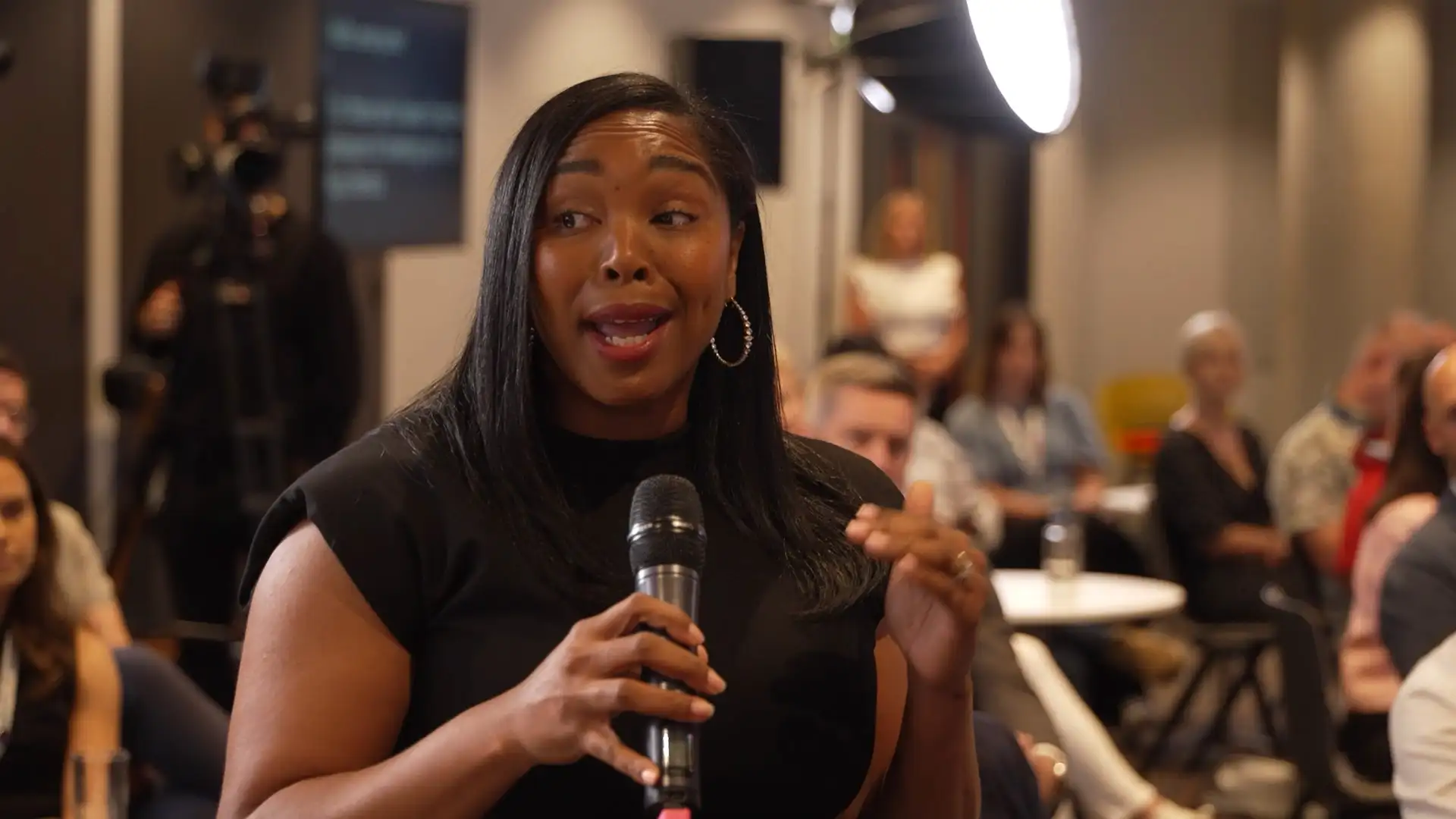 Audience member speaking into a microphone during a live, interactive event session.