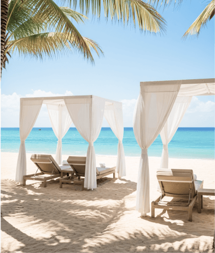 Seaside café with wooden deck seating along a sandy beach and scenic mountain backdrop.