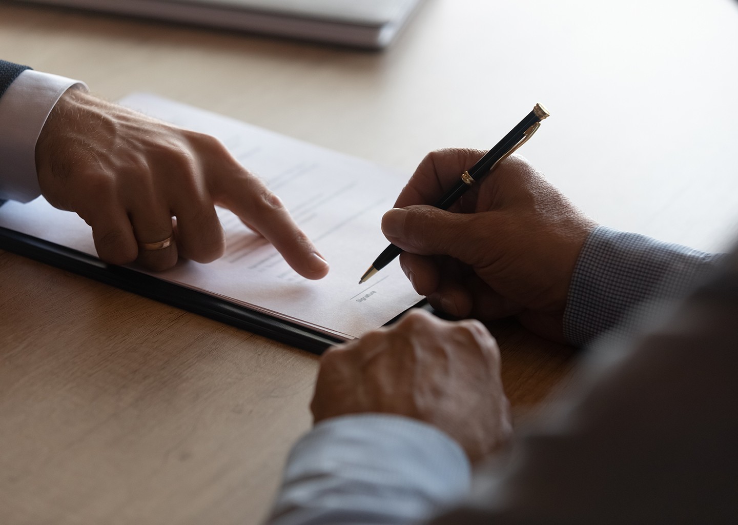 Ufficio moderno dove un manager fa firmare un contratto di lavoro al dipendente