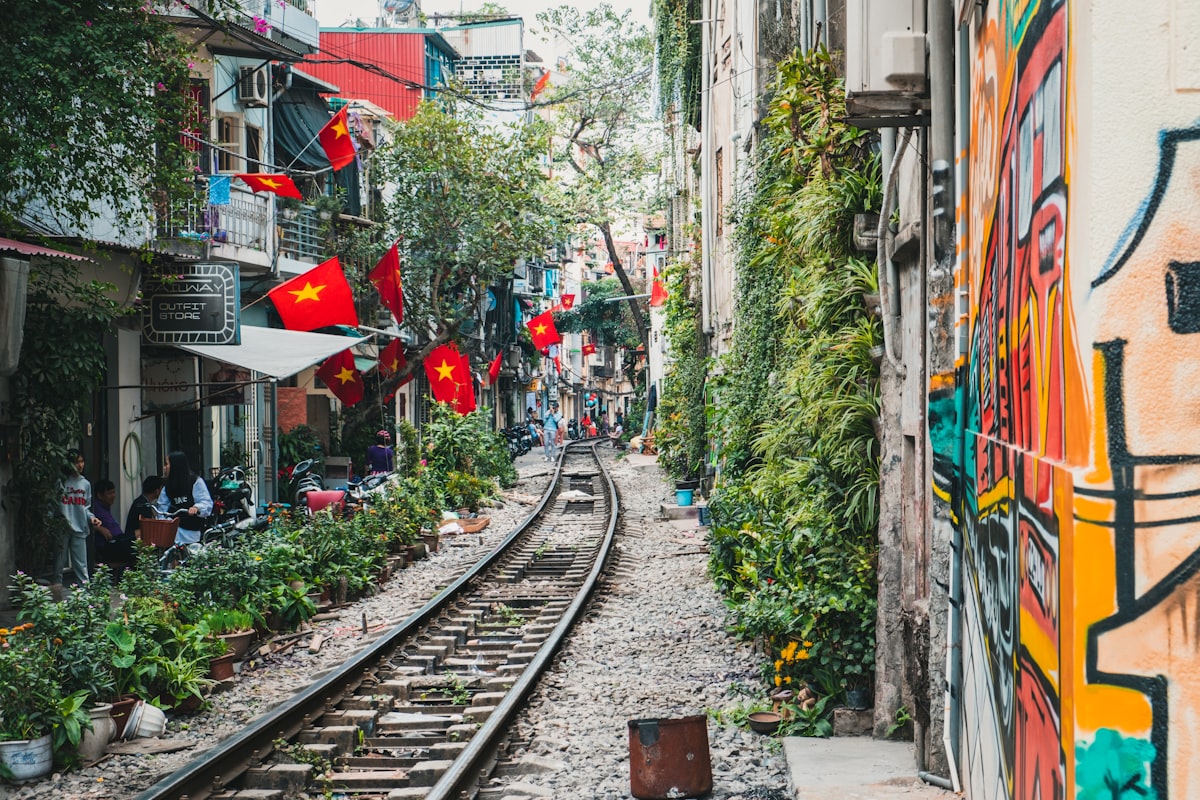 Hanoi Train Street with railway tracks running between homes and cafes on a Vietnam travel itinerary stop