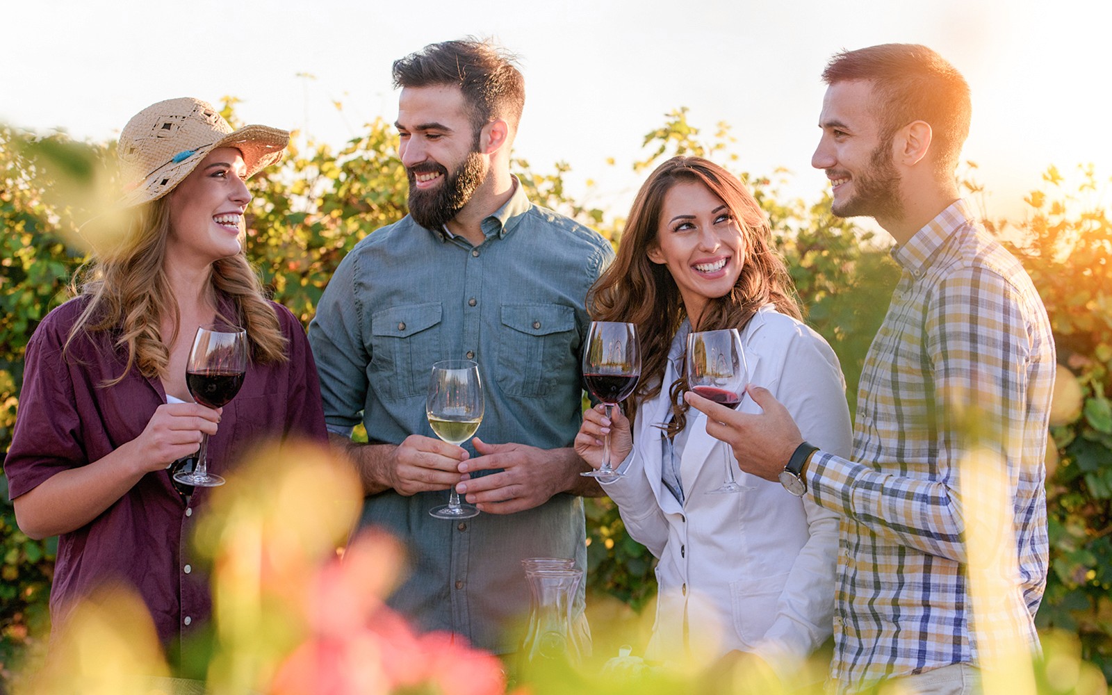 Friends enjoying wine in a vineyard setting.