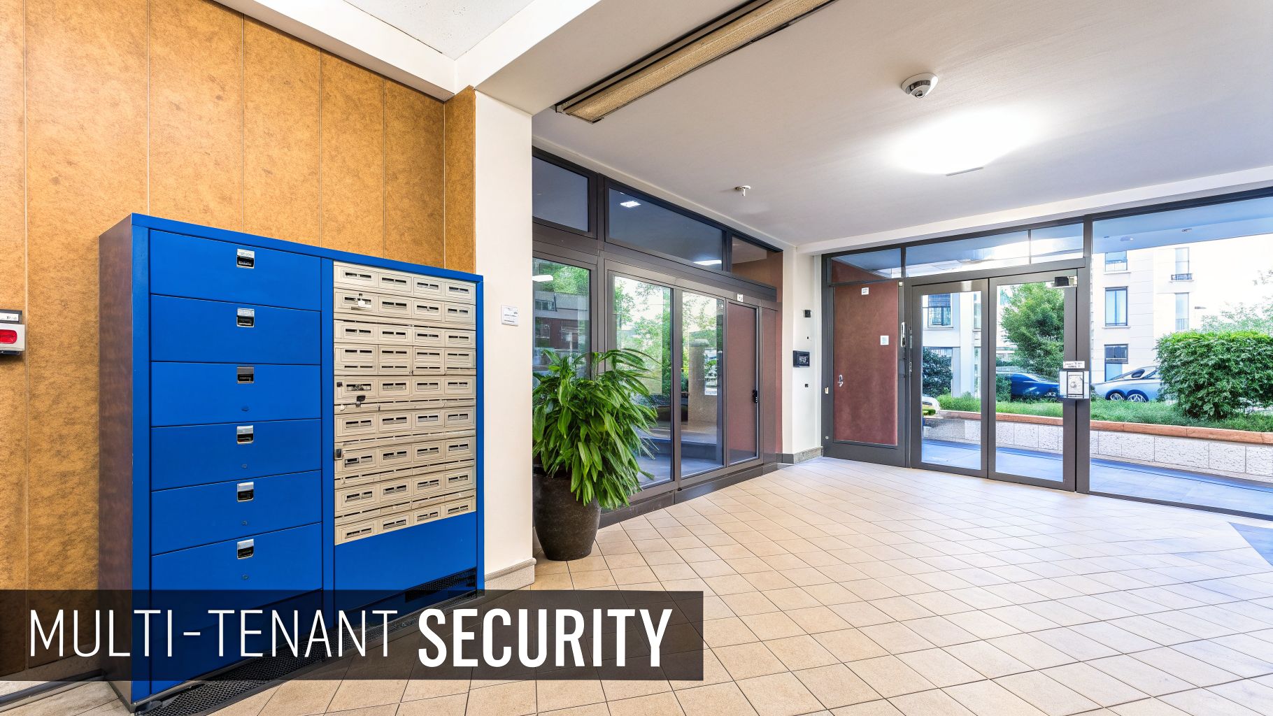 Modern multi-tenant building entrance featuring a blue mailbox system and glass doors.