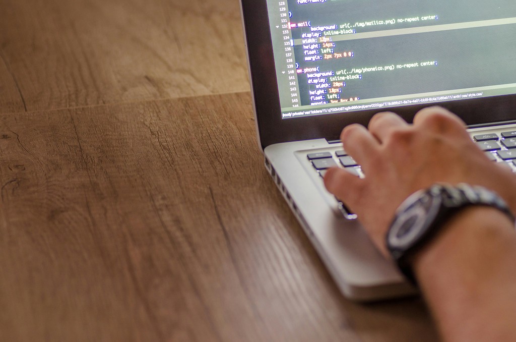 Software engineer typing code on a laptop, preparing for a SWE interview with Cracking the Coding Interview strategies.