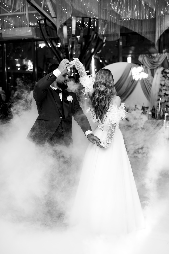 A bride in a lace wedding dress gently holds.