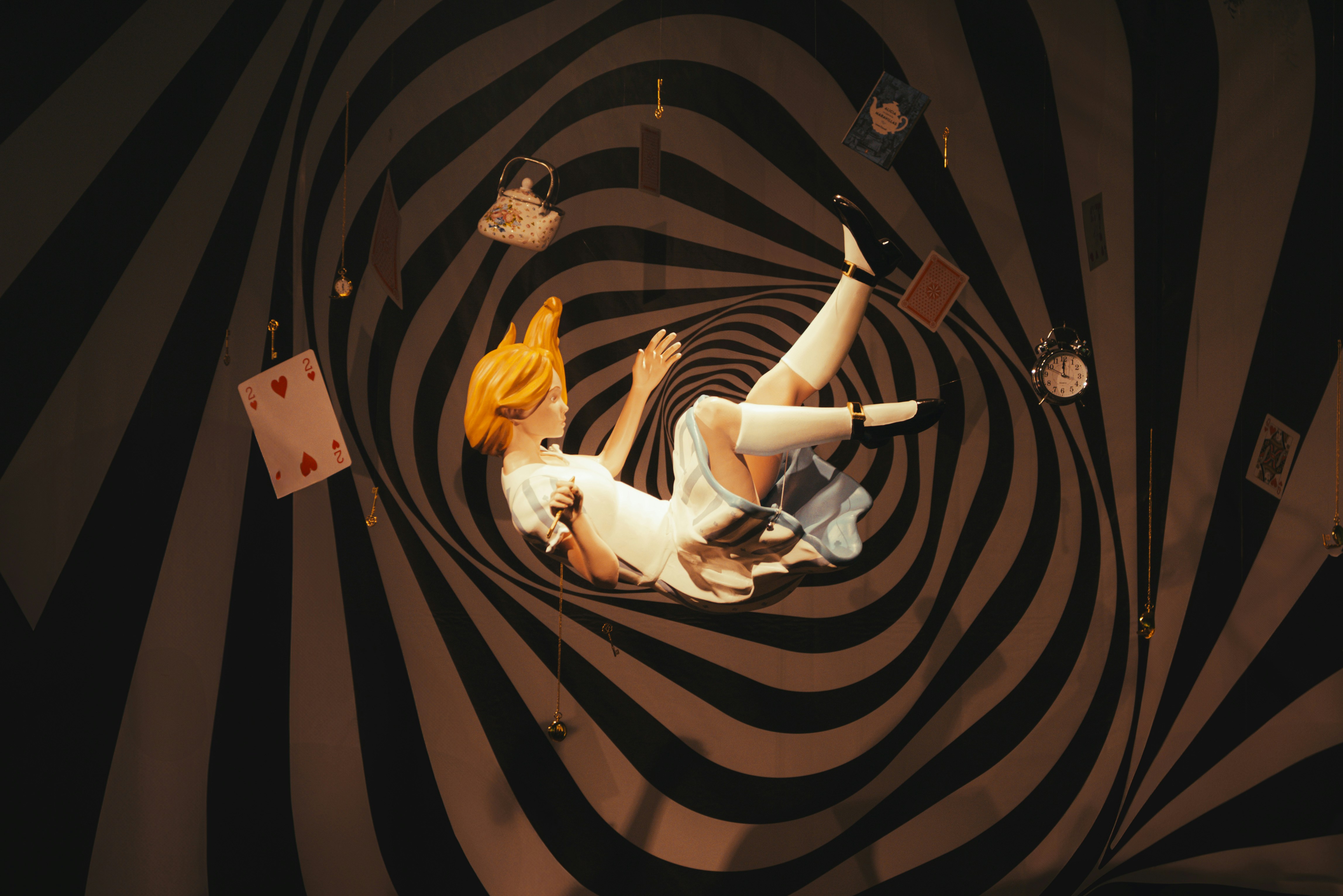 Woman falling through a swirling vortex with playing cards.