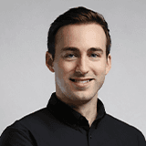 Profile portrait of a man in a white shirt against a light background