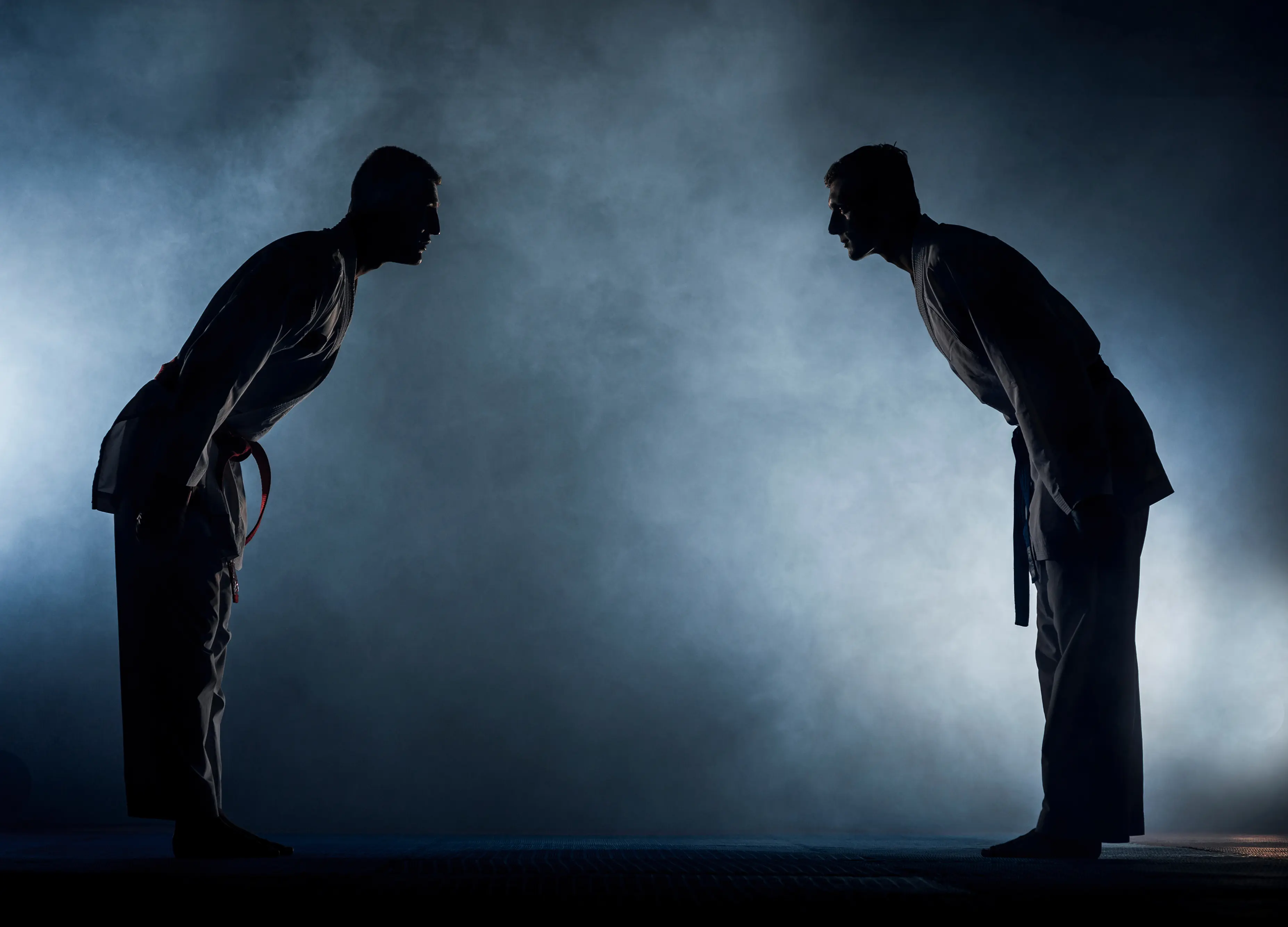 Two Brazilian Jiu Jitsu practitioners bowing to each other in a respectful training stance