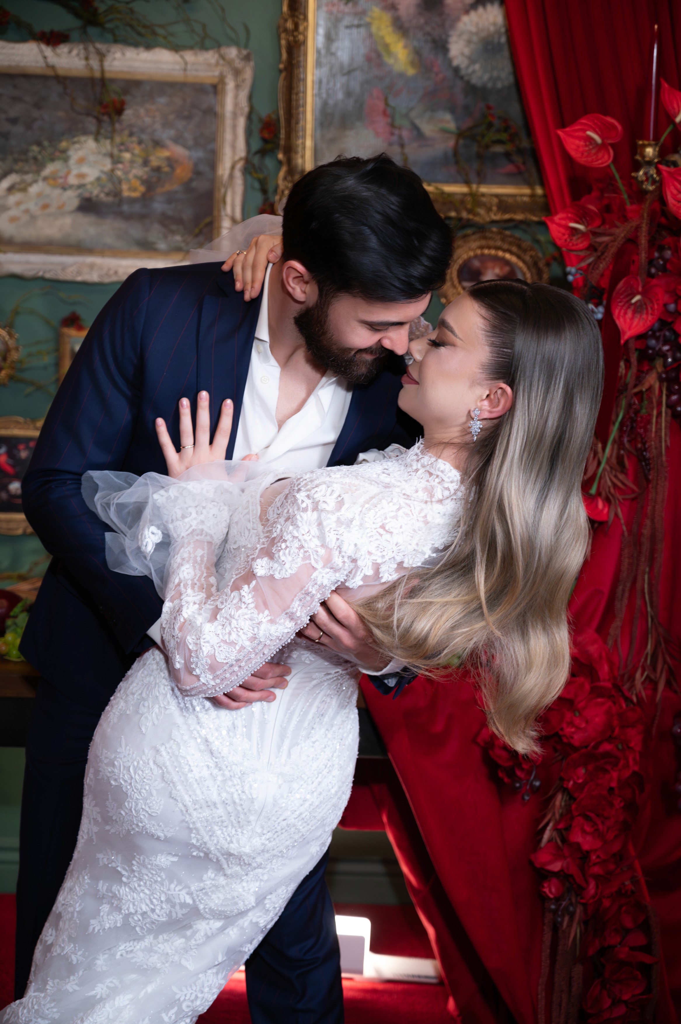 Mire și mireasă fotografiați într-un decor elegant cu draperii roșii și lumină cinematică, ședință foto de nuntă în București