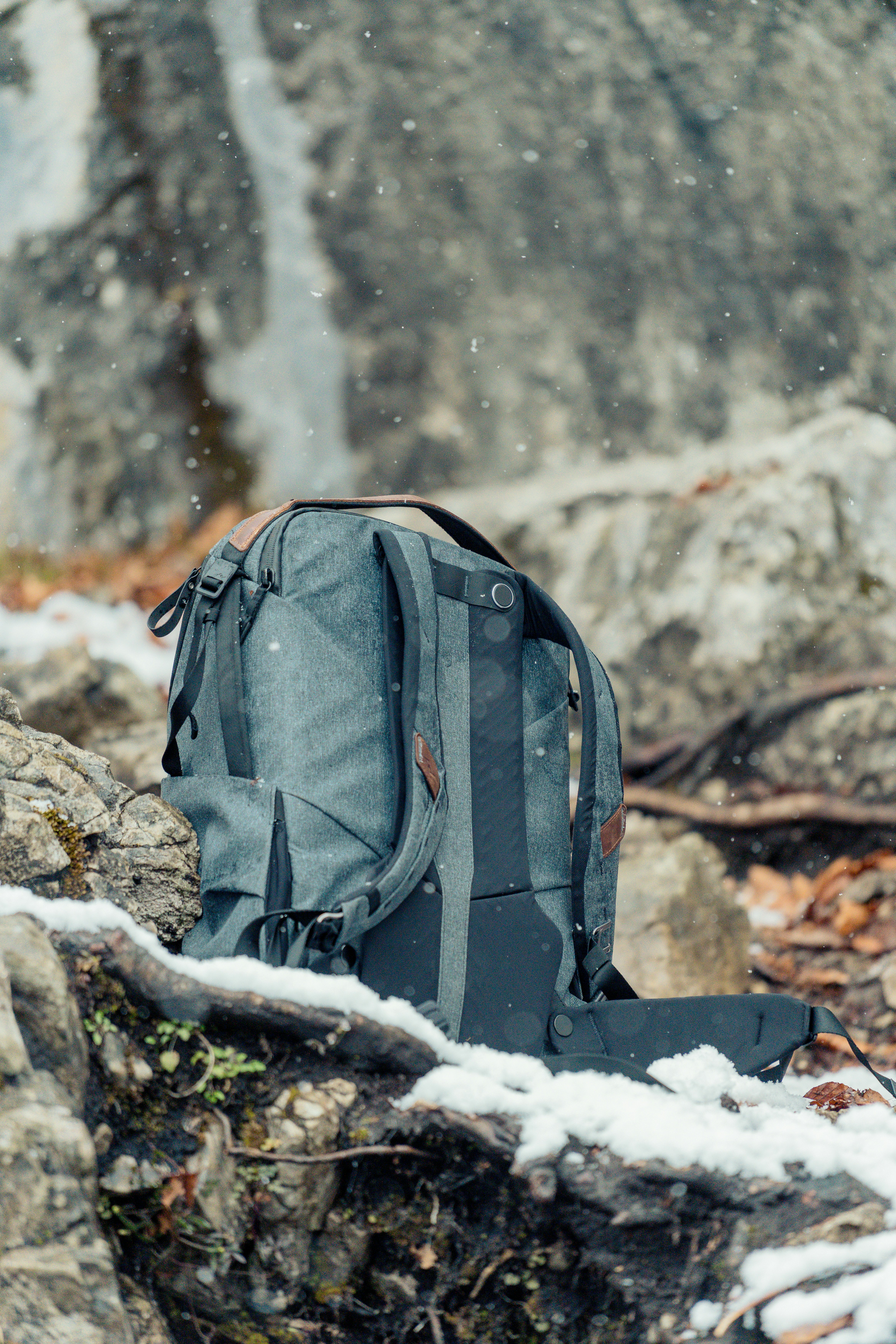 a backpack sitting on a rock in the snow