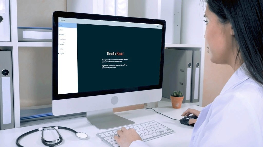 Two individuals working at computer stations, with code displayed on large monitors—representing cybersecurity operations or secure software development in progress.