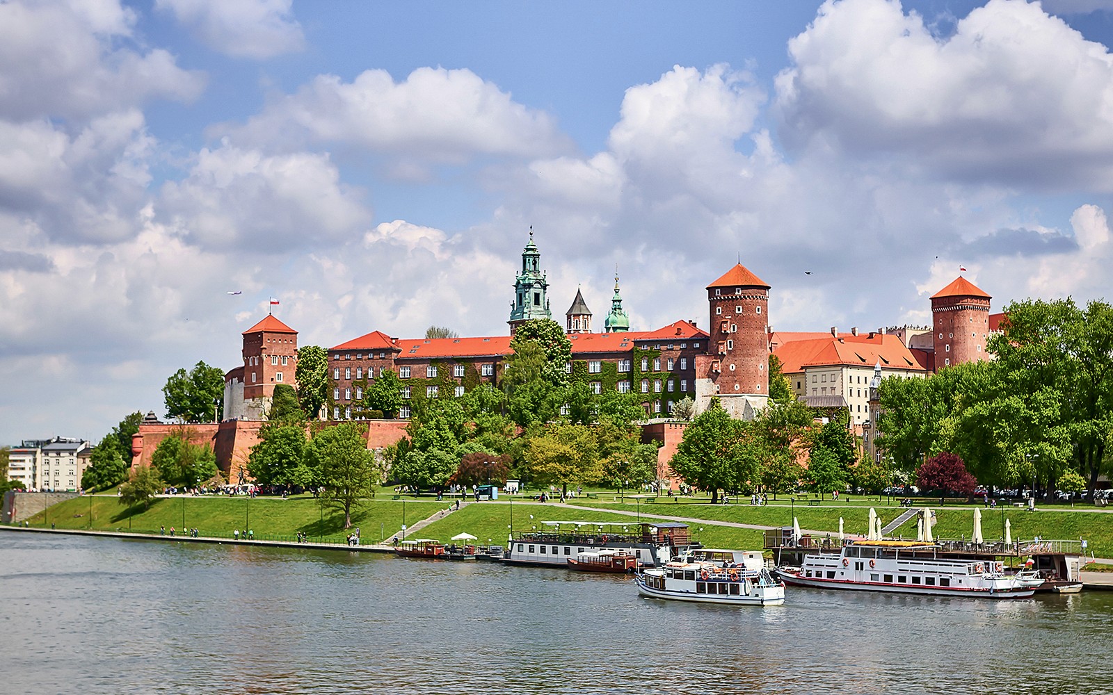 Zamek Wawelski w Krakowie widziany z Wisły z łodziami wycieczkowymi.