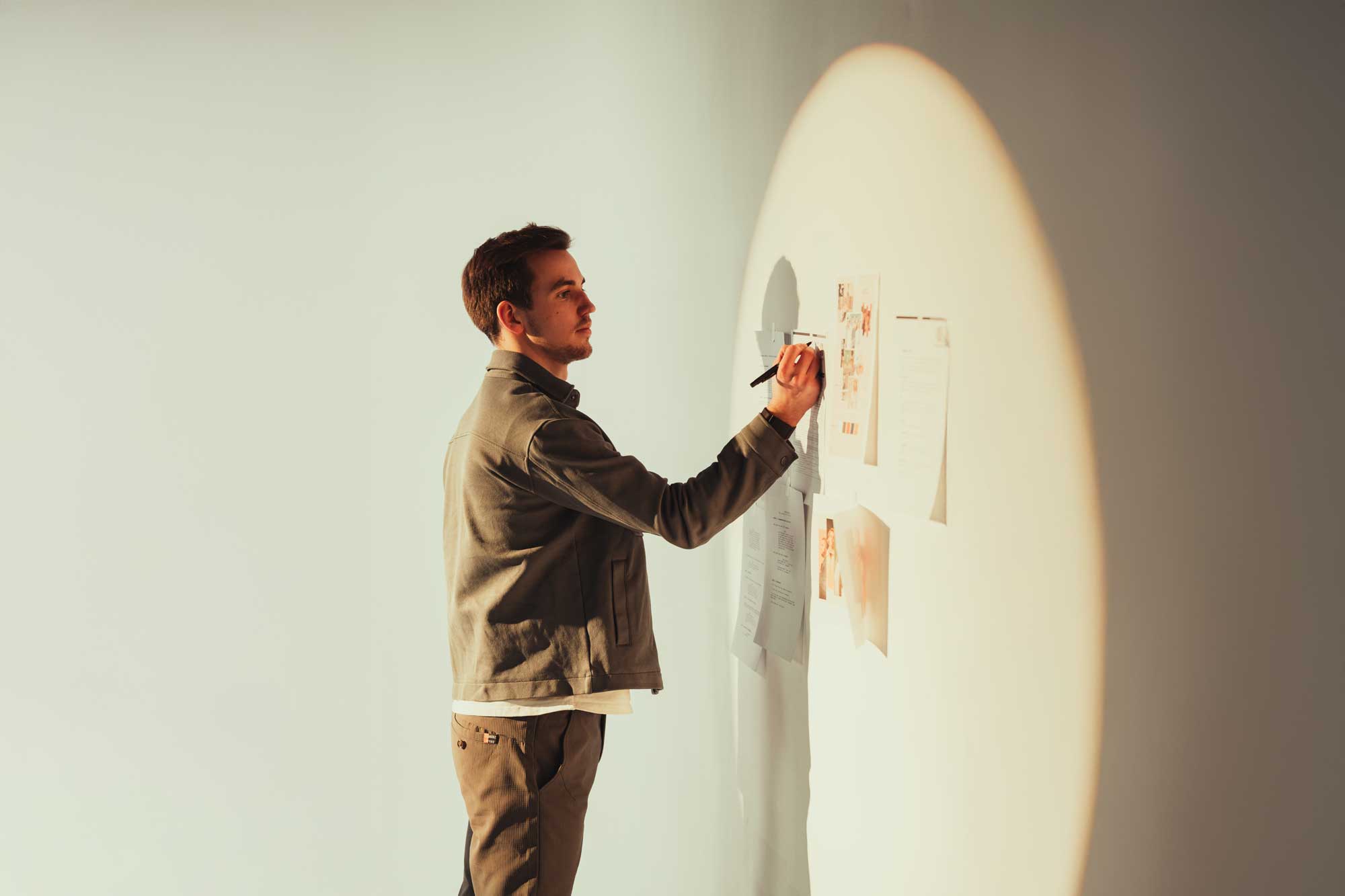 Man planning campaign on wall; filmproduction, ads, conception focus.