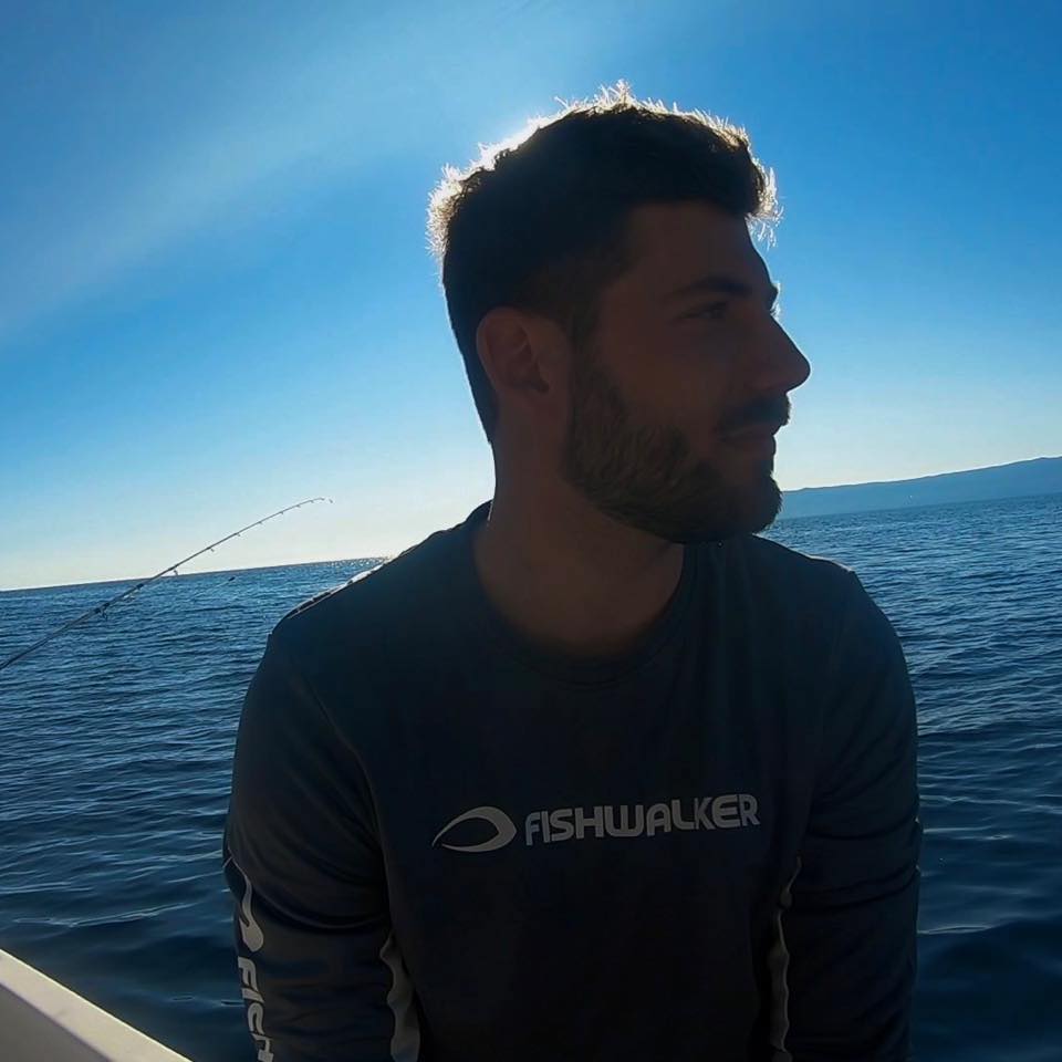 Portrait of a boat captain steering a motorboat on the Adriatic Sea, enjoying a sunny day at sea.